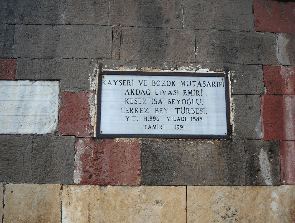 An octagonal Ottoman-era domed mausoleum (kümbet) dated 1587–88, standing in the courtyard of the 'Domed Mosque' in Çayıralan.